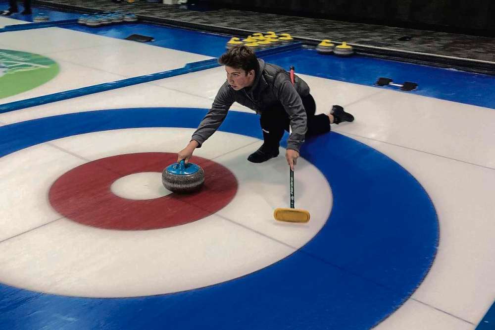 Supplied photo
Luke Robins slides across the ice as he takes his shot with the West Kildonan curling squad.