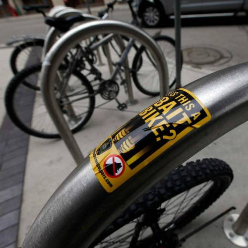 File photo
                                Bait Bike stickers were displayed on bicycle racks at the Millennium Library in 2018.