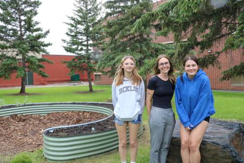 Photo by Rylee Gerrard
                                Transcona Collegiate Grade 10 students Kaylynn Seavers (left) and Maddison Lacey (right) beside the medicine garden they proposed and led into creation with help from geography instructor Brandi Haider.