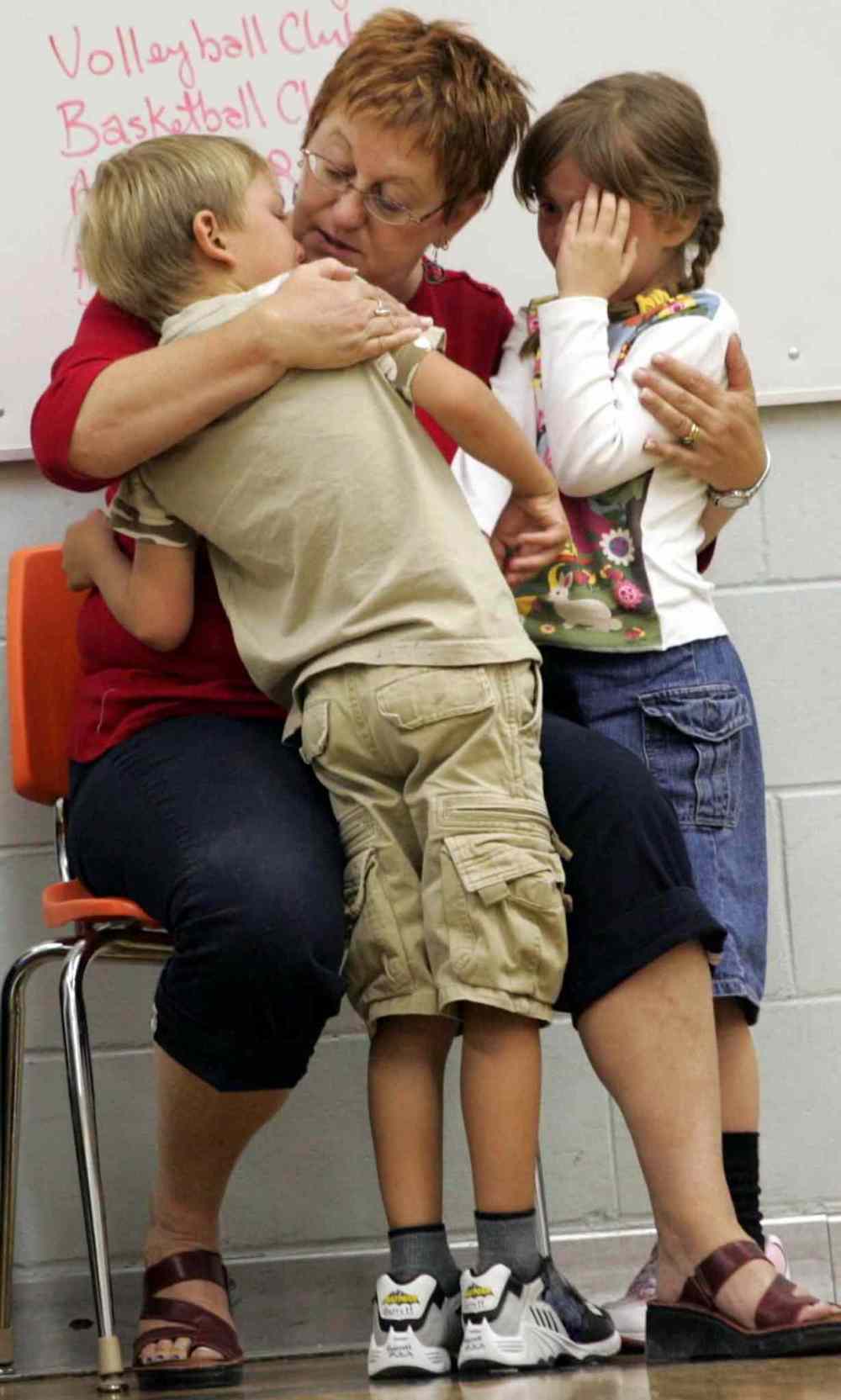 Education Assistant Jean Boiteau comforts Garrett and Sydney after a collision in a game in gym class (Wayne Glowacki / Winnipeg Free Press)