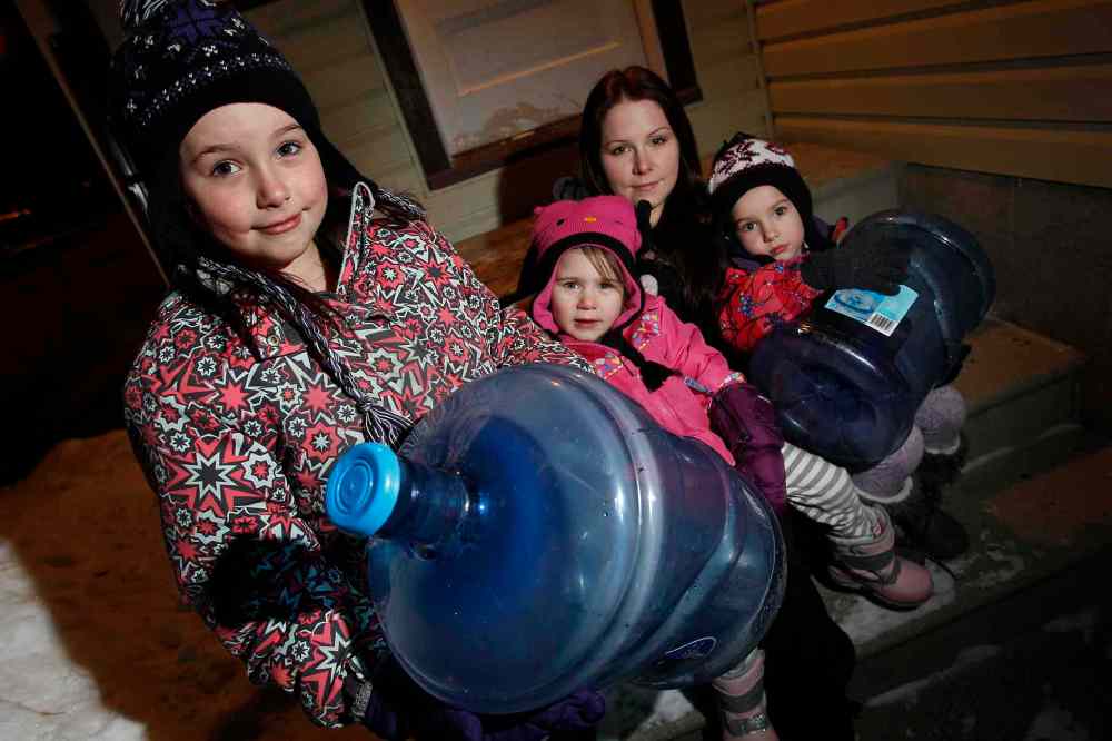 John Woods / Winnipeg Free Press
Kaylee Mack and her three young daughters (from left to right) Maykenzie, Gracelyn, and Keanna head out to get water at their grandparents' home Monday. They have been without water for 8 days.