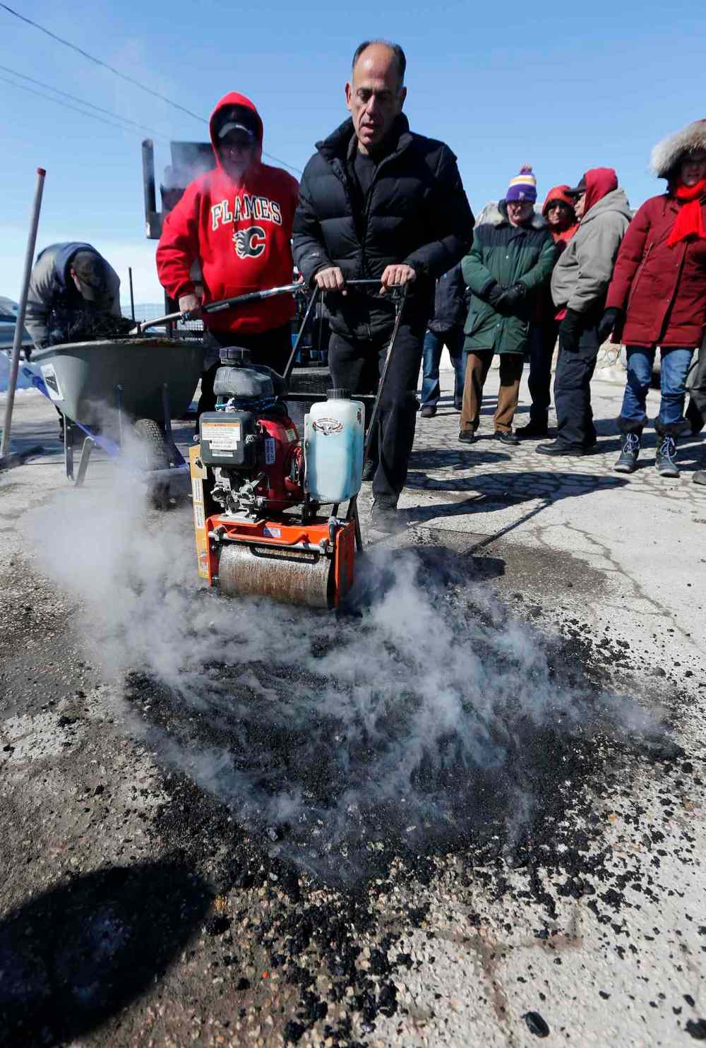 KEN GIGLIOTTI / WINNIPEG FREE PRESS
Pellet Patch sales rep Saverio Marra uses a roller to smooth hot mixture into a pothole. The City of Winnipeg currently uses a cold-mix patching material during the late winter and early spring to fill potholes.