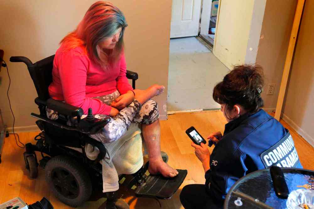 BORIS MINKEVICH / WINNIPEG FREE PRESS
EPIC team member Karen Martin  takes a photo of Tammy's leg. She will send it to the doctor to help decide on care.