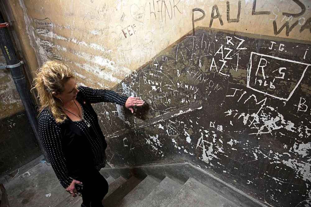Metropolitan Entertainment Centre general manager Janet Harder in the building's back employee staircase in 2016.  The staircase was kept in its original state so as not to disturb graffiti that dates back more than 50 years. (Mike Deal / Winnipeg Free Press)