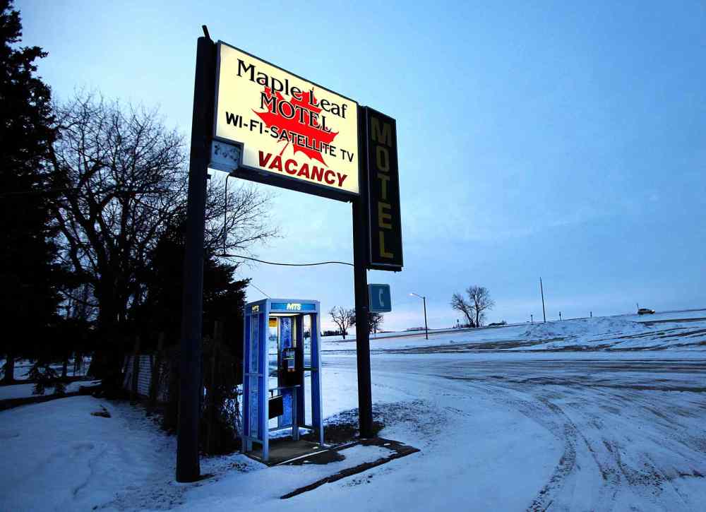 The Maple Leaf Motel's sign glows in the dawn light in Emerson.