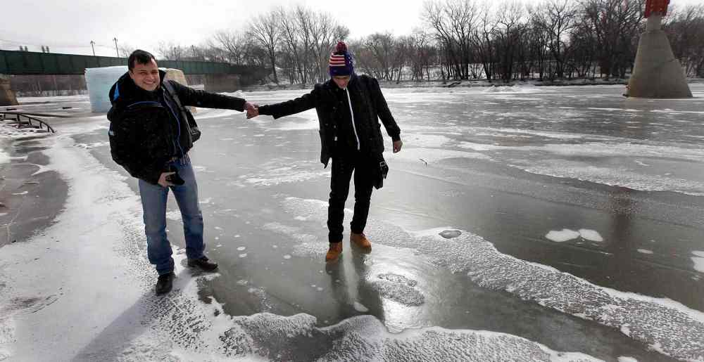 49.8 FEATURE :
PHIL HOSSACK / WINNIPEG FREE PRESS - Shahadat Hossain (left) and Subir Barman take their first tenative steps to walk on a frozen Assinaboine river Wednesday morning, neither had ever seen a frozen waterway. Randy Turner / Melissa Martin story. - March 3, 2017