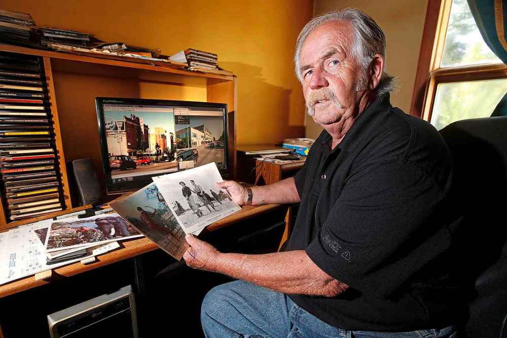 JOHN WOODS / WINNIPEG FREE PRESS
Robert Callaghan looks through old photos of the corner of Logan and Main, which once had five theatres. (John Woods / Winnipeg Free Press)
