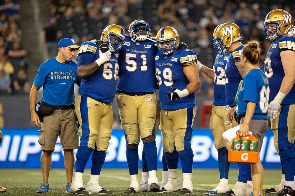 ANDREW RYAN / WINNIPEG FREE PRESS FILES
Jermarcus Hardrick (51) is carried off by Stanley Bryant (66) and Sukh Chungh (69) after being injured in Bombers game action against the Ottawa Redblacks at Investors Group Field on August 17, 2018.