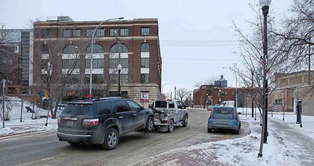 MIKE DEAL / WINNIPEG FREE PRESS
The city was towing cars Wednesday evening along Rupert and Lily while people were at the MTC Warehouse theatre.
181206 - Thursday December 6, 2018
