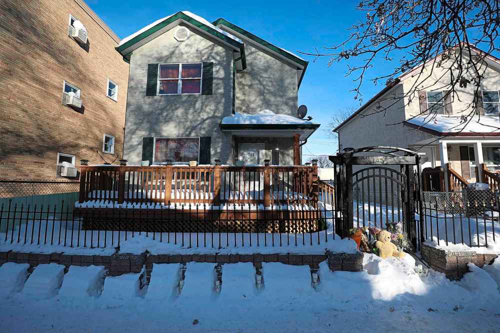 A memorial of flowers and a teddy bear sit on the steps to the gate of home where 17-year-old Jamie Adao was killed. (Ruth Bonneville / Winnipeg Free Press files)