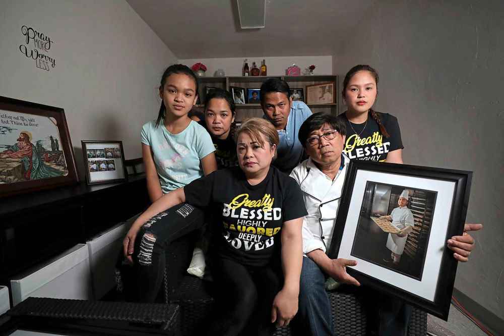 Imelda Adao and Jaime Adao Sr. with their family. From left to right: Granddaughter Kristlyn Cain Parayno, daughter Germelyn, son Michael and daughter Emerald. (Ruth Bonneville / Winnipeg Free Press)