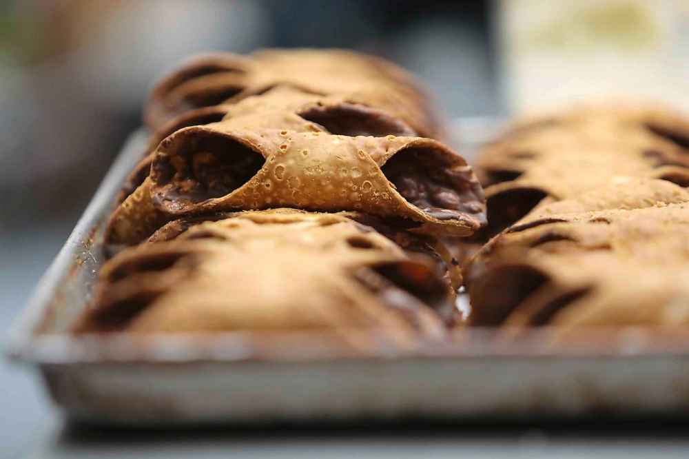A tray of chocolate cannoli waiting to be filled with cream. (Ruth Bonneville / Winnipeg Free Press)