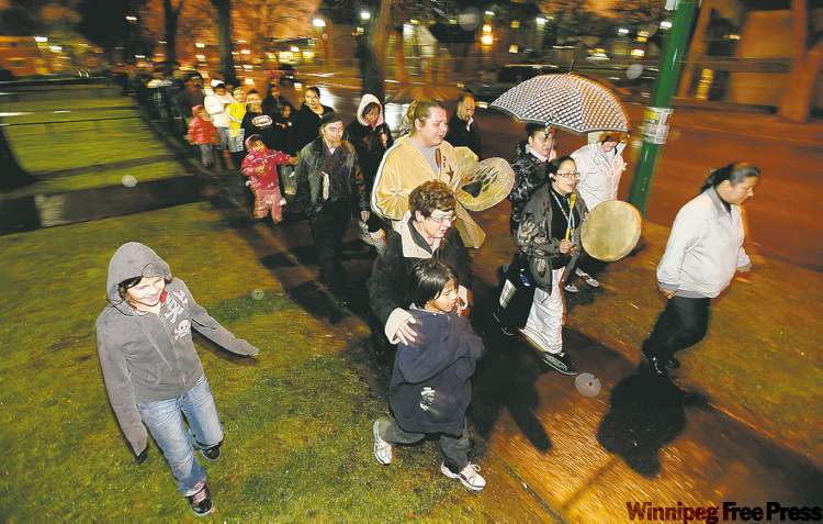 JOHN WOODS / WINNIPEG FREE PRESS
Mayoral candidate Judy Wasylycia-Leis (in black-and-white jacket) is joined by about 200 people on Monday night for a vigil for the shooting victims’ families.
