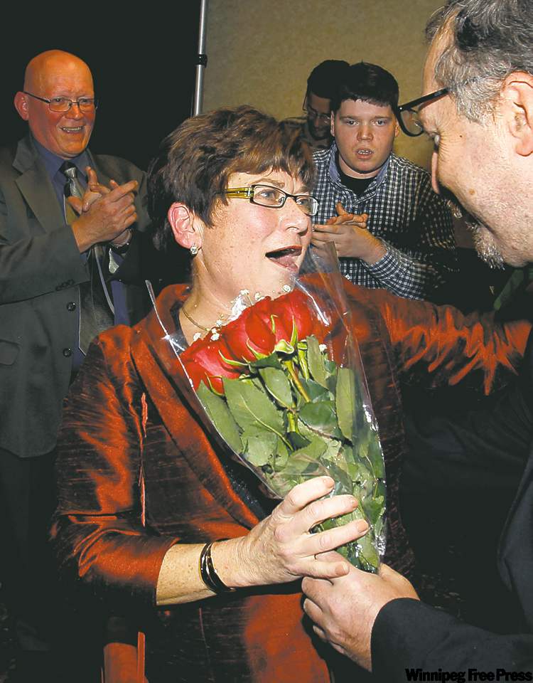 WAYNE.GLOWACKI@FREEPRESS.MB.CA
Judy Wasylycia-Leis reacts after getting roses on arrival at rally after polls closed Wednesday.