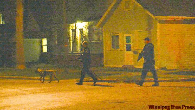 SHAUN MCLEOD PHOTO
Police officers hunt for a suspect on Oct. 23 following a shooting rampage that killed two.