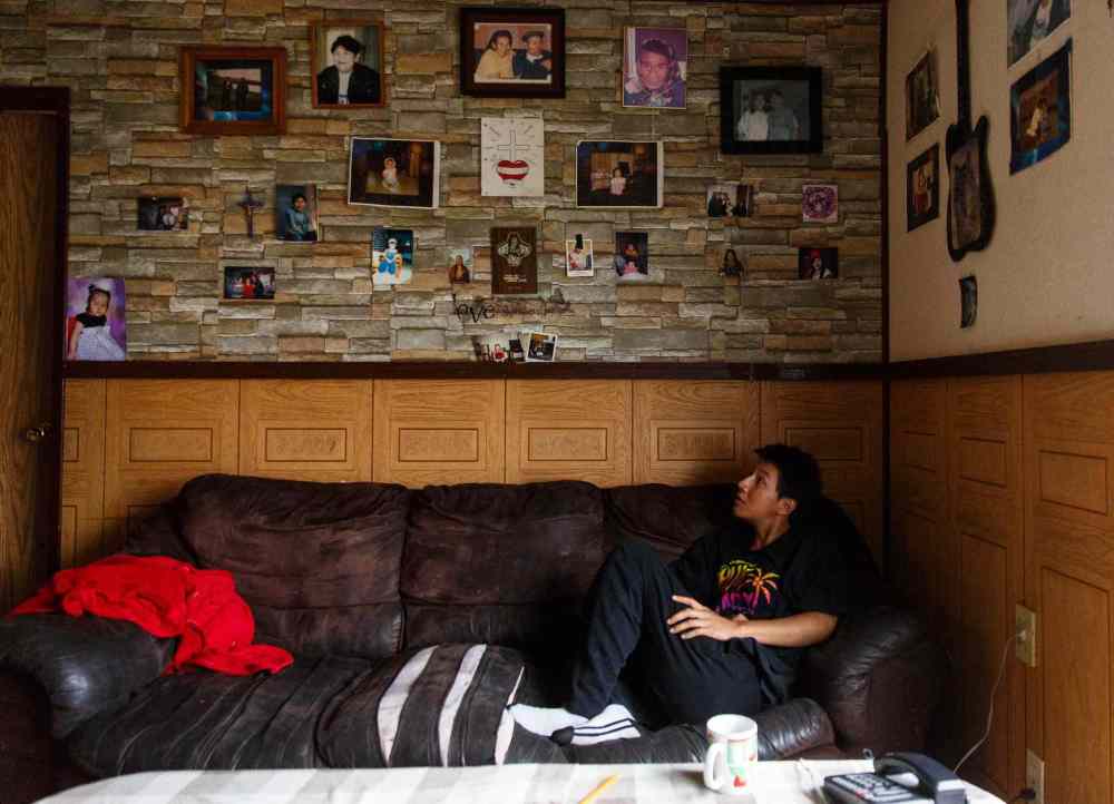 Mike Deal / Winnipeg Free Press
Sherilyn Hill sits on her couch below photos of her family. It took a long time before Sherilyn finally got a house to live in, even though it doesn't have any running water.