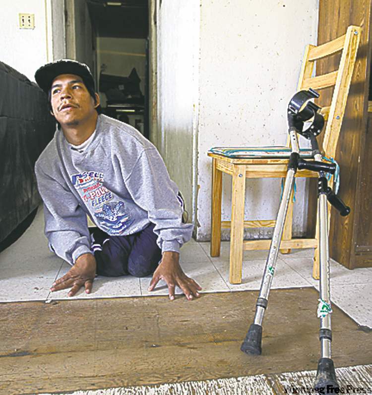 30 year old Kevin Taylor who has Cerebral palsy icrawls on his floor to get to his crutches in his home in St Theresa Point First Nation- His mother Alice has filled a Human Rights  to  get proper services for her son on the reservation. Their home has no running water- See Mary Agnes No Running Water Feature � August 19, 2011   (JOE BRYKSA / WINNIPEG FREE PRESS)