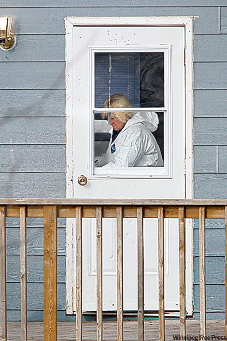 Postmedia
A forensics officer gathers evidence inside the home Friday.