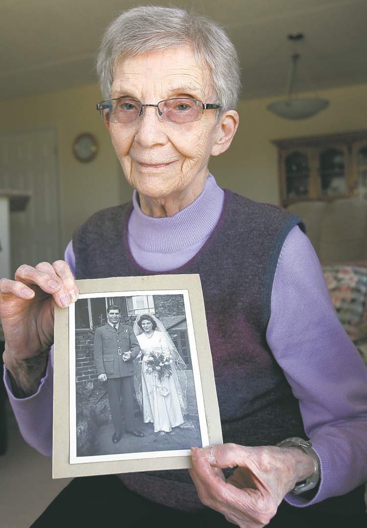 Rose Lindsay holds a photo of their wedding in 1945.