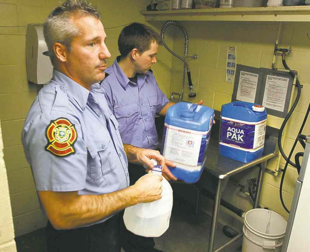 Boris Minkevich / Winnipeg Free Press
Winnipeg firefighters and paramedics prepare water jugs for delivery at Winnipeg Fire and Paramedic Station 22, 1567 Waverley St. Jay Simons and Dale Worrall demonstrate how they are going to clean and fill the water jugs.