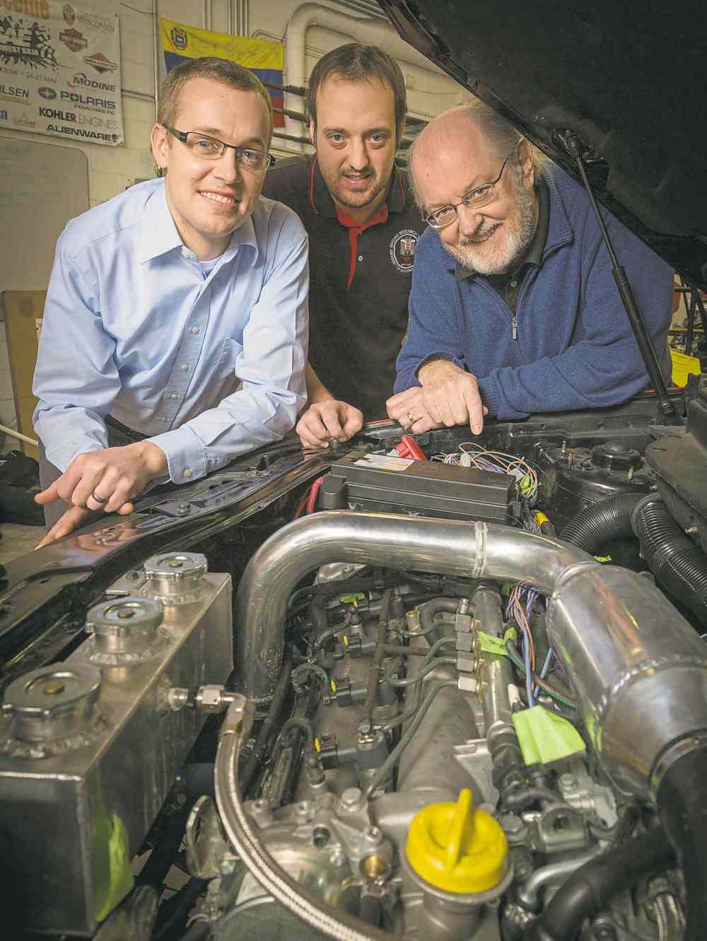 Andy Manis Photo
Prof. Sage Kokjohn (from left), researcher Derek Splitter and Prof. Rolf Reitz show off an engine that mixes diesel with gasoline.