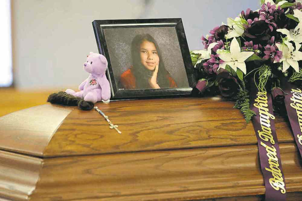 Purple flowers and a treasured teddy bear surround Tina Fontaine�s photograph on her casket. Purple was her favourite colour.