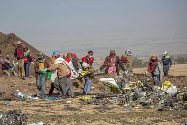 Rescuers work at the scene of an Ethiopian Airlines flight crash near Bishoftu, or Debre Zeit, south of Addis Ababa, Ethiopia, Monday, March 11, 2019. A spokesman says Ethiopian Airlines has grounded all its Boeing 737 Max 8 aircraft as a safety precaution, following the crash of one of its planes in which 157 people were killed. (AP Photo/Mulugeta Ayene)