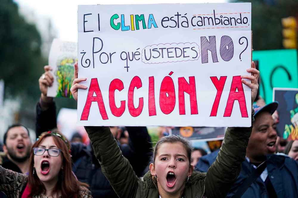 Matilde Campodonico / The Associated Press
A young woman holds up a sign with a message that reads in Spanish: