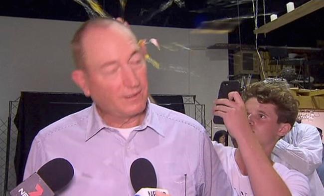 In this image made from video, a teenager breaks an egg on the head of Senator Fraser Anning while he holds a press conference, Saturday, March 16, 2019, in Melbourne, New Zealand. Following the mass shootings on Friday, Anning came under sharp criticism over tweets including one that said: “Does anyone still dispute the link between Muslim immigration and violence?” (AP Photo)