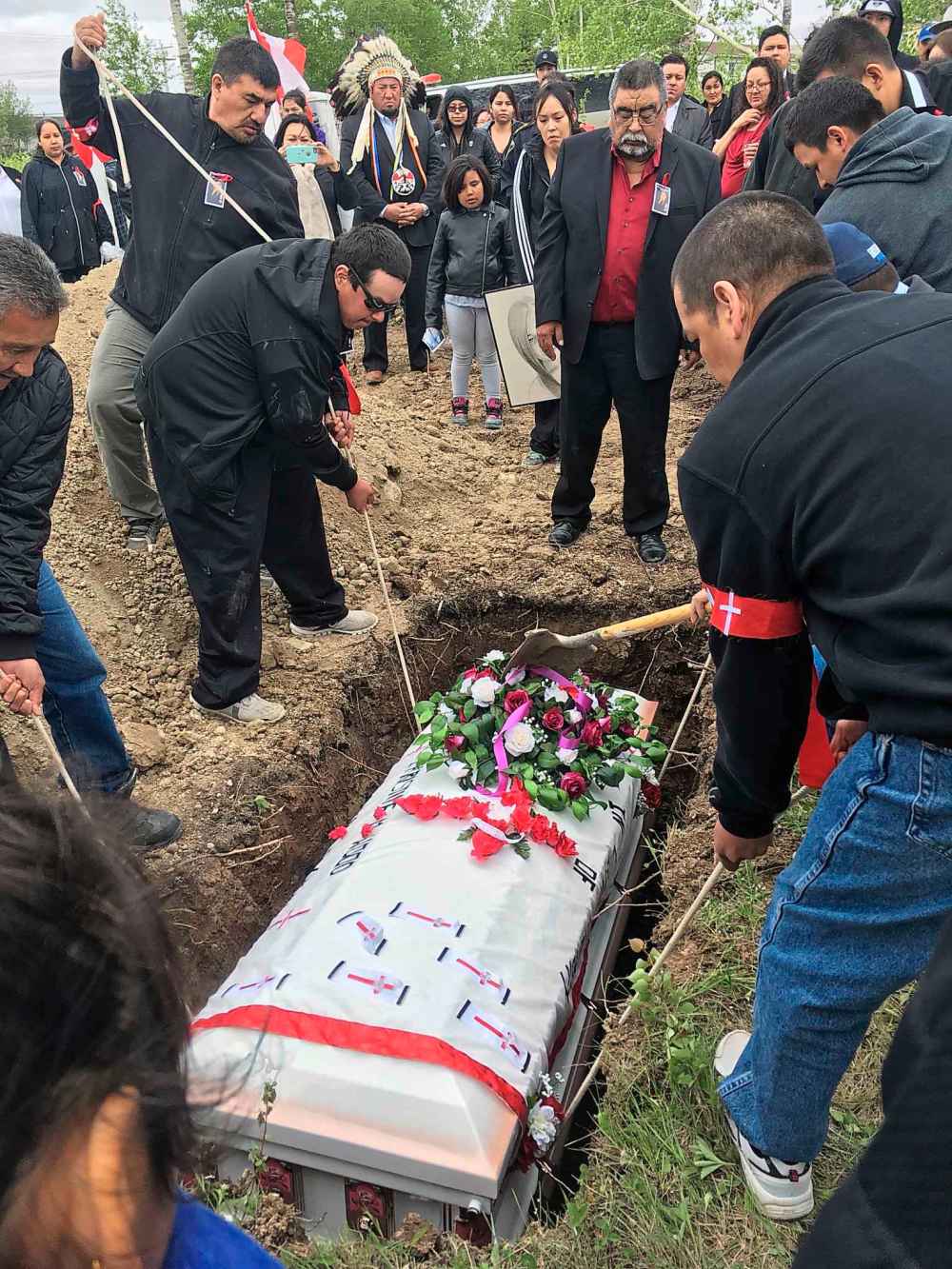 MELISSA MARTIN / WINNIPEG FREE PRESS FILES
Bunibonibee Cree Nation Chief Tim Muskego looks on as community members lower Christine Wood’s casket into the ground in Oxford House. The community held a funeral service for the young woman June 10, 2017.