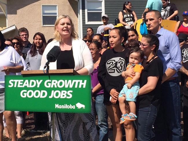 Manitoba Family Services Minister Kerri Irvin-Ross, makes an announcement on Friday, May 22, 2015 behind a sign bearing the government's Steady Growth, Good Jobs slogan. A former commissioner of Elections Manitoba says the Manitoba government needs to clarify the rules governing government advertising, especially during election periods. THE CANADIAN PRESS/Steve Lambert
