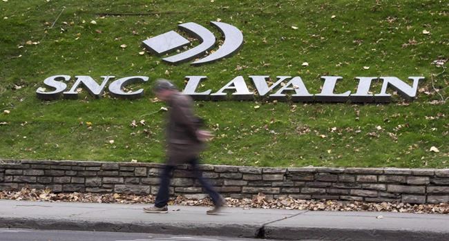 A man walks past the headquarters of SNC-Lavalin in Montreal on November 6, 2014. THE CANADIAN PRESS/Paul Chiasson