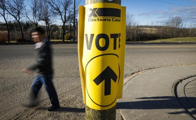 A voter walks past a sign directing voters to a polling station for the Canadian federal election in Cremona, Alta., Monday, Oct. 19, 2015. Welcome to the official start of the federal election campaign, which comes with some obvious questions about party promises and platforms, but also some others that seem to come up each time the country votes.THE CANADIAN PRESS/Jeff McIntosh
