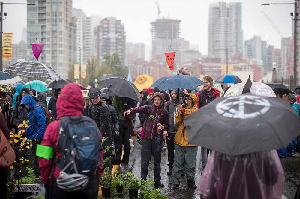 Protesters with the group Extinction Rebellion occupy the Burrard Street Bridge in Vancouver, closing it to vehicle traffic going into and out of downtown. (Darryl Dyck / The Canadian Press)