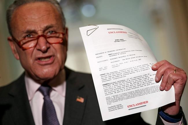 Senate Minority Leader Sen. Chuck Schumer of N.Y. holds up a copy of a released transcript of a phone call between President Donald Trump and the President of Ukraine as Schumer speaks to the media about an impeachment inquiry on President Trump, Wednesday Sept. 25, 2019, on Capitol Hill in Washington. (AP Photo/Jacquelyn Martin)