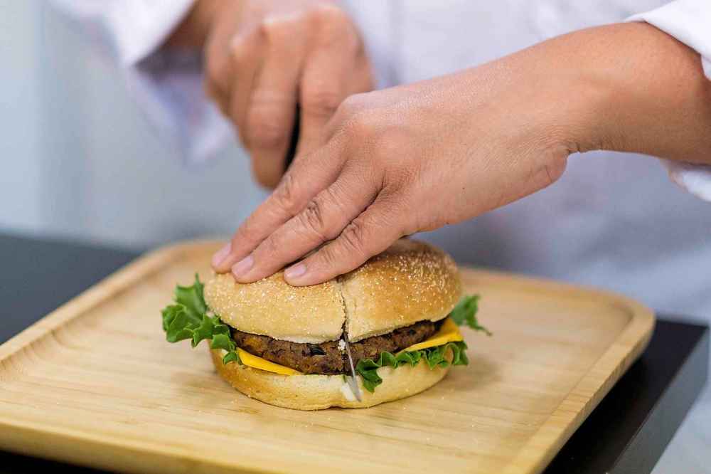 Daniel Crump / Winnipeg Free Press
Sarah Medina cuts into a plant based burger developed by Burcon.