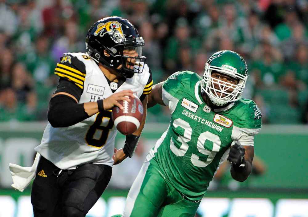 Mark Taylor / THE CANADIAN PRESS
Hamilton Tiger-Cats quarterback Jeremiah Masoli, left, is chased by Saskatchewan Roughriders defensive lineman Charleston Hughes during second half CFL action at Mosaic Stadium in Regina on Thursday, July 5, 2018.
