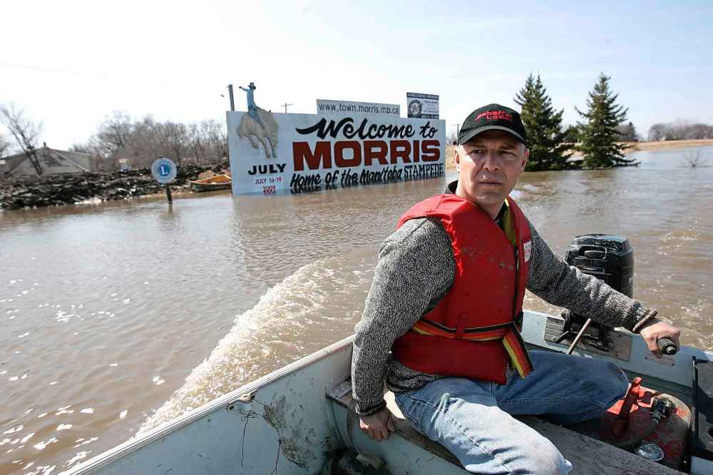 Ruth Bonneville / Winnipeg Free Press Files
Barry Penner takes a boat into the town of Morris, MB. in 2009 because of flooding of the Red River. Morris was protected by a high ring dike causing Highway 75 to stay closed at Morris for 37 days