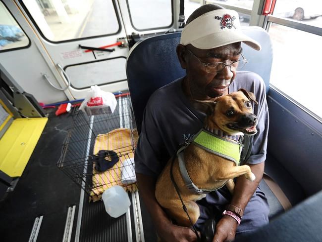 Eddie Wright, 68, and his dog Vino wait on one of the final buses at Lanier Plaza in Brunswick, Ga., to evacuate from Hurricane Dorian. (Curtis Compton/Atlanta Journal-Constitution via AP)