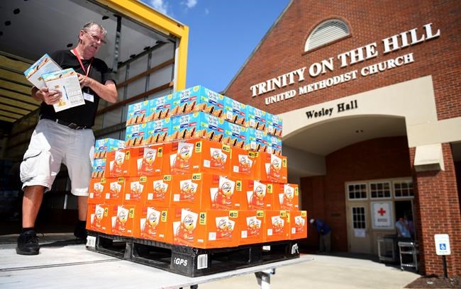 Red Cross volunteer Dennis Cadman packs a pallet of snacks for delivery to Trinity On The Hill United Methodist Church, Tuesday, Sept. 3, 2019 in Augusta, Ga., where Hurricane Dorian evacuees are being sheltered. (Michael Holahan/The Augusta Chronicle via AP)