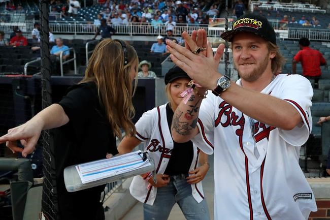 U.S. Olympic snowboarder Kyle Mack reacts as he is introduced to the crowd before announcing Thursday, Sept. 5, 2019, that SunTrust Park in Atlanta will host a Big Air competition. The high-flying ski and snowboarding event will be held Dec. 20-21 at SunTrust Park, bringing some of the top athletes from the United States and around the world to compete off a 15-story-tall tower that will be built in the center of the 41,000-seat baseball stadium. (AP Photo/John Bazemore)