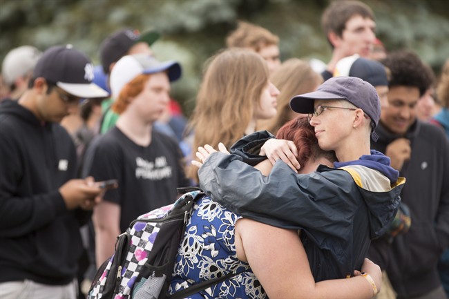 A woman is comforted during a rally in Woodstock, Ont. after hundreds of high school students in the town walked out of classes, Tuesday, June 7, 2016 to raise awareness of a suicide crisis which is gripping the small Ontario community. THE CANADIAN PRESS/ Geoff Robins