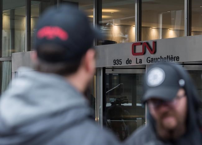 CN rail workers gather outside CN headquarters in Montreal, Tuesday, Nov. 26, 2019. THE CANADIAN PRESS/Graham Hughes