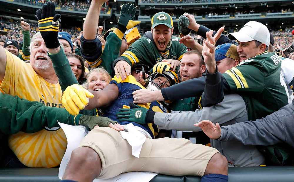 (AP Photo/Jeffrey Phelps)
Green Bay Packers fans celebrate a touchdown run with a player in Green Bay, Wis. There's no reason a small-market NHL hockey team can't generate the same interest from television viewers as Green Bay does, the smallest market in the NFL.