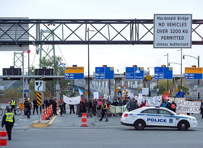 Members of Extinction Rebellion, protesting issues related to climate change, gather at the Angus L. Macdonald Bridge in Dartmouth, N.S. on Monday, Oct. 7, 2019. The bridge was closed to all traffic in early morning rush hour. Protests are expected in other Canadian cities including Burrard Street Bridge in Vancouver and Prince Edward Viaduct in Toronto. THE CANADIAN PRESS/Andrew Vaughan