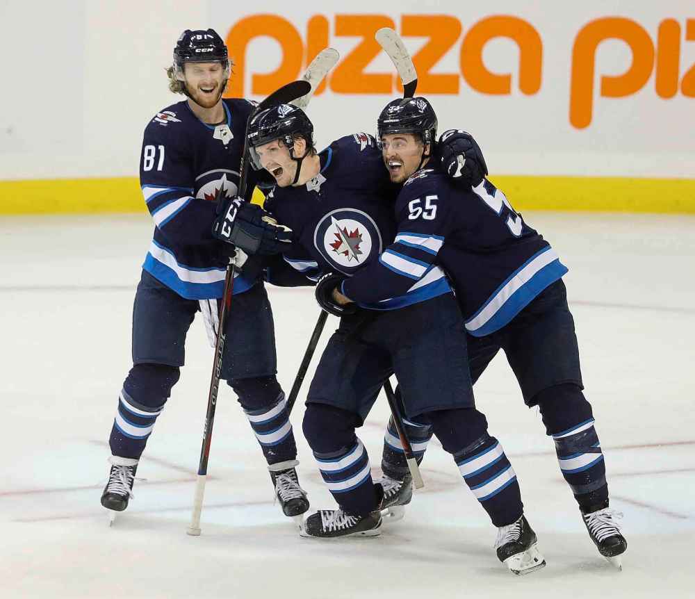 Trevor Hagan / The Canadian Press
Winnipeg Jets' Kyle Connor (81), Jacob Trouba (8), and Mark Scheifele (55) celebrate after Trouba scored the game winning goal against the St. Louis Blues during overtime NHL hockey action in Winnipeg, Monday.