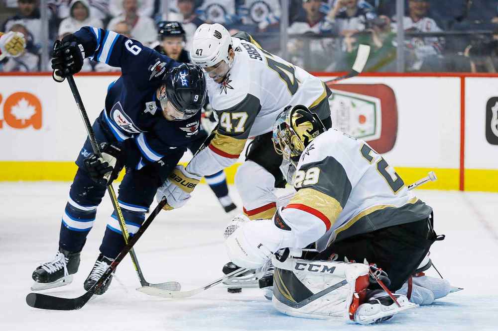 Vegas Golden Knights' goaltender Marc-Andre Fleury (29) knocks the puck away from Winnipeg Jets' Andrew Copp (9) as Knights' Luca Sbisa (47) defends during second period of game one action in the NHL Western Conference Final in Winnipeg on Saturday, May 12, 2018. (John Woods / The Canadian Press)
