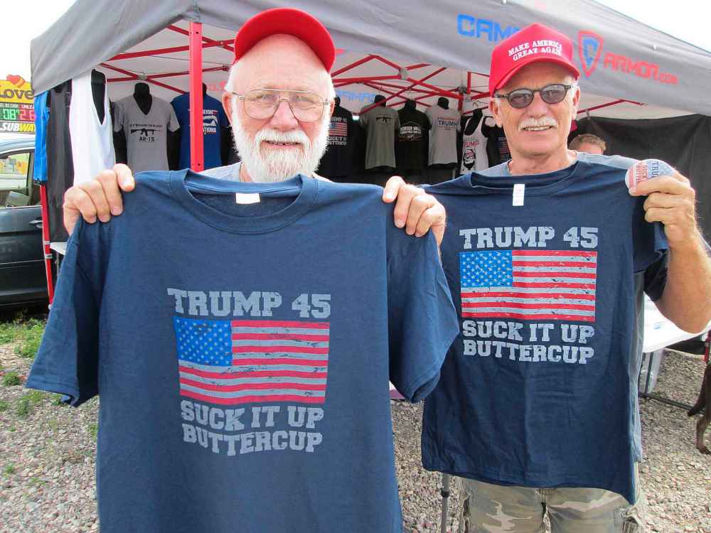 ADAM TREUSCH / WINNIPEG FREE PRESS
Brothers Bob Tanner (left) of Horace, N.D., and Ken Tanner of Texas bought the same T-shirts from peddler Michael Goodart of Springfield, Mo., on Tuesday, June 26, 2018 at his stand in a parking lot in Fargo, N.D., a day before U.S. President Donald Trump holds a rally there.