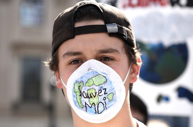 A protester wears a mask that reads