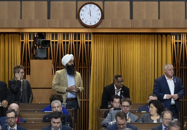 The clock reads one minute to midnight as Liberal MPs Brenda Shanahan, left, Randeep Sarai, Ramesh Sangha and Darrell Samson rise to vote during a marathon voting session as it continues into the night in the House of Commons on Parliament Hill in Ottawa on Wednesday, March 20, 2019. THE CANADIAN PRESS/Justin Tang